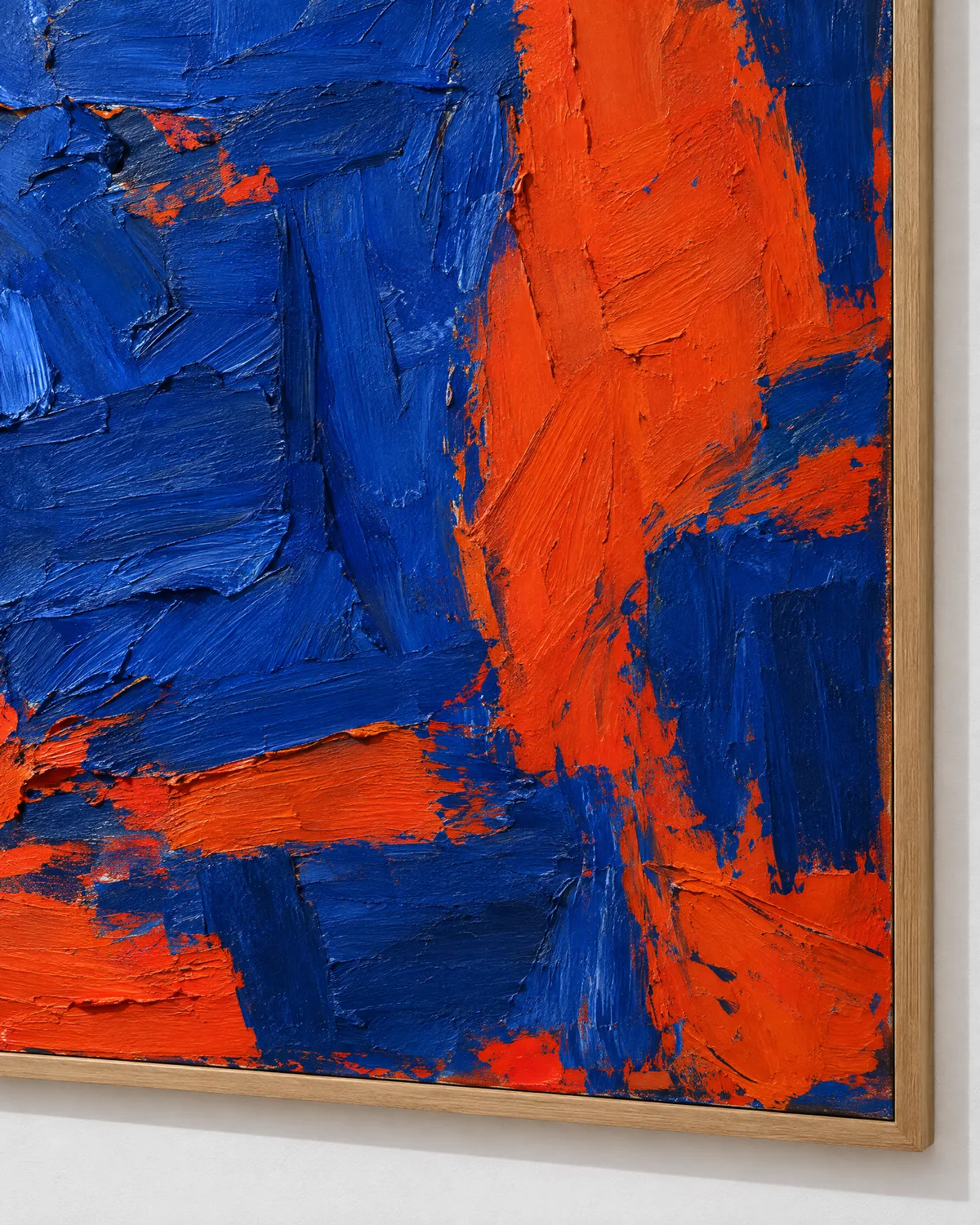 A large cobalt and vermilion painting beside a walnut door.